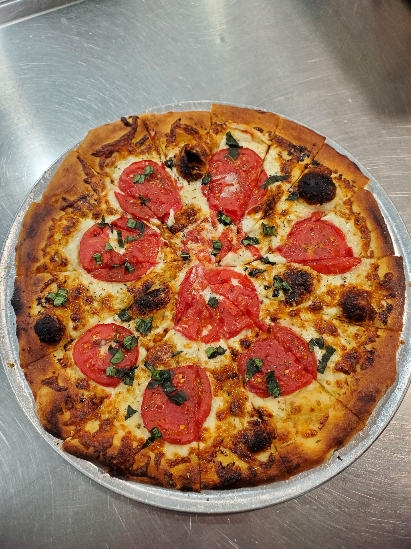 Margherita-style pizza topped with fresh tomatoes and basil